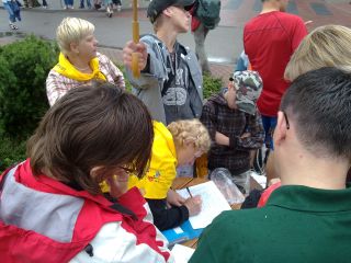 Rafał trzyma parasol nad mamą Alą, która zapisuje Maćka…